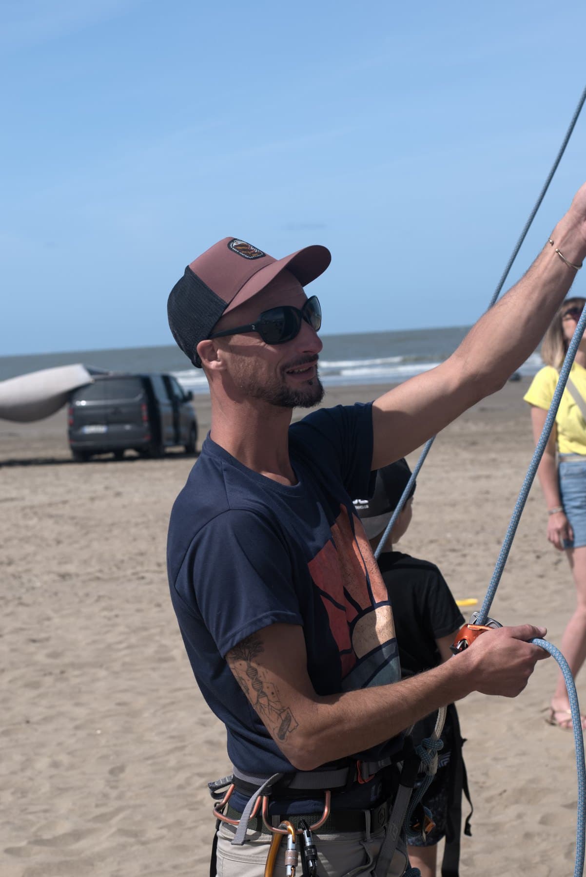 L'encadrant, corde en main, au pied du mur pendant une session